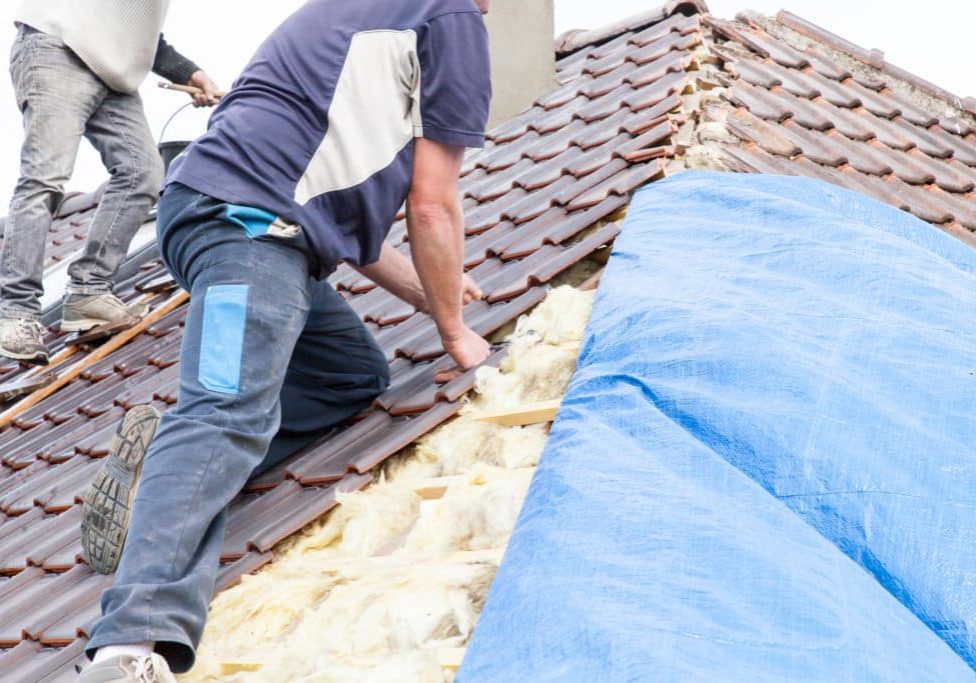 a roofer laying tile on the roof a roofer laying tile on the roof